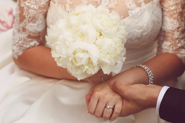 Hands of bridal couple holding beautiful bouquet — Stock Photo, Image