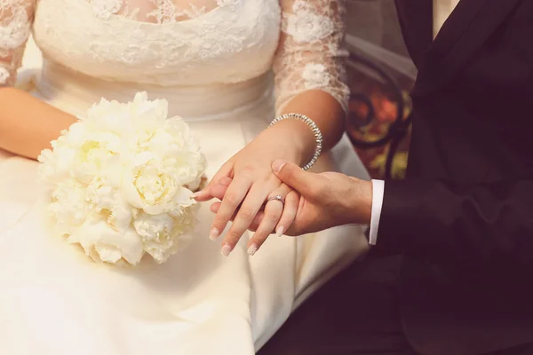 Hands of bridal couple holding beautiful bouquet — Stock Photo, Image