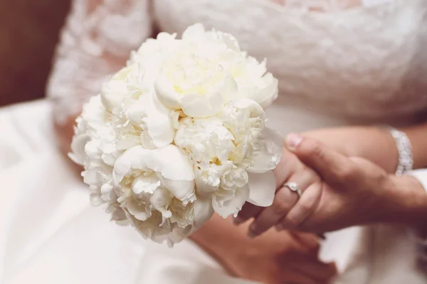 Mãos de casal nupcial segurando belo buquê — Fotografia de Stock