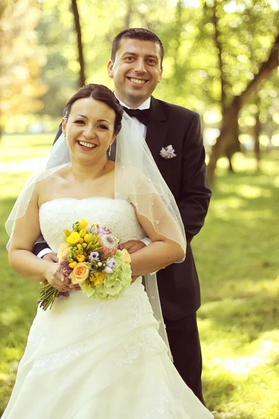 Feliz casal nupcial abraçando no parque — Fotografia de Stock