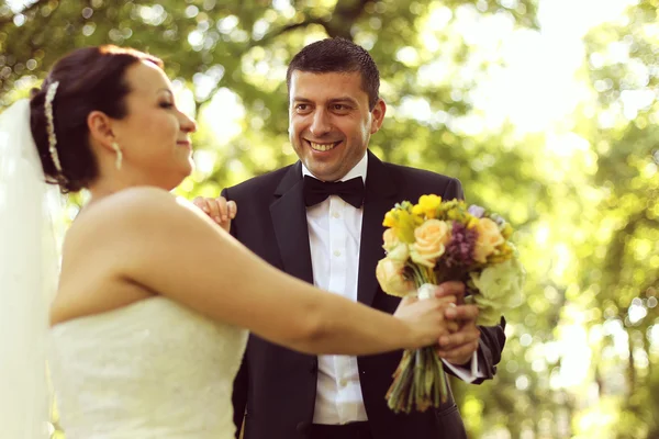 Feliz casal nupcial abraçando no parque — Fotografia de Stock