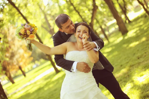 Feliz pareja de novias abrazándose en el parque — Foto de Stock