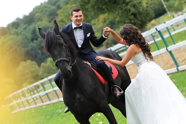 Braut und Bräutigam haben Spaß beim Reiten — Stockfoto