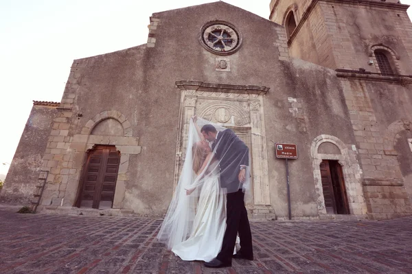 Blijde bruid en bruidegom met plezier en omarmen in het oude centrum — Stockfoto