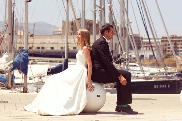 Joyful bruden och brudgummen omfattar nära båtar — Stockfoto