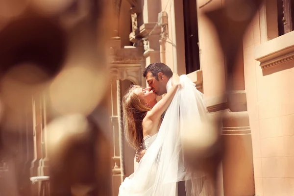 Joyful  bride and groom embracing in old city — Stock Photo, Image