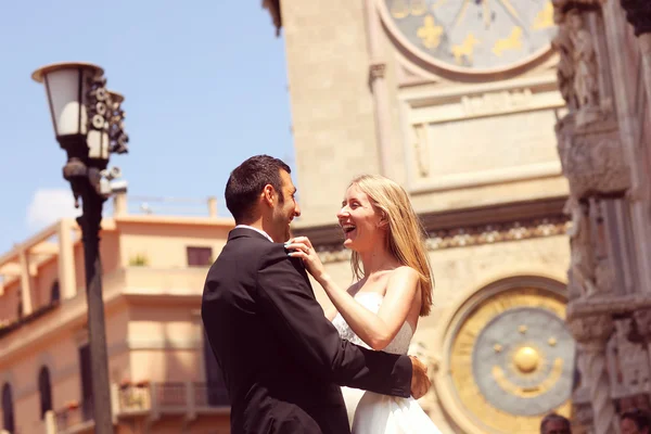 Joyful bruden och brudgummen embracing i gamla staden — Stockfoto