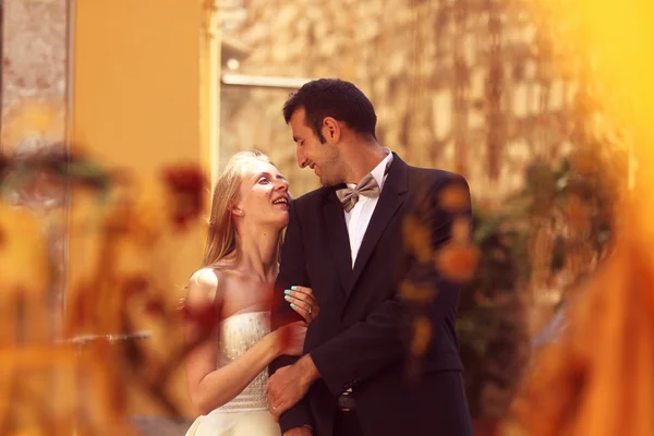 Joyful  bride and groom embracing in old city — Stock Photo, Image