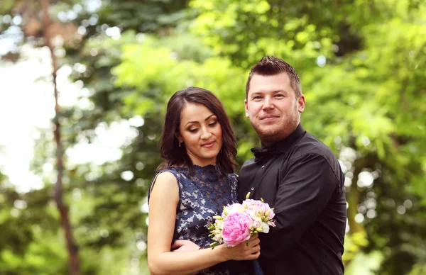 Joyful couple with beautiful bouquet getting married — Stock Photo, Image