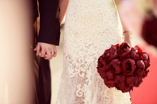 Freudige Braut und Bräutigam am Hochzeitstag mit schönem Tulpenstrauß — Stockfoto