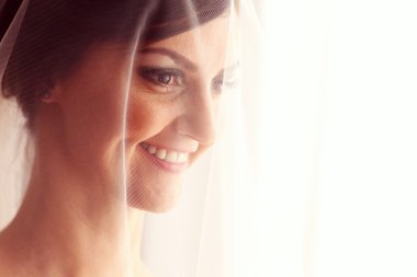 Güzel gelin düğün gününde gülümseyen örtü ile portresi