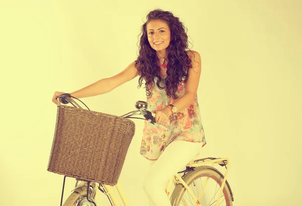 Genç ve güzel kadın stüdyoda bir bisiklet üzerinde — Stok fotoğraf