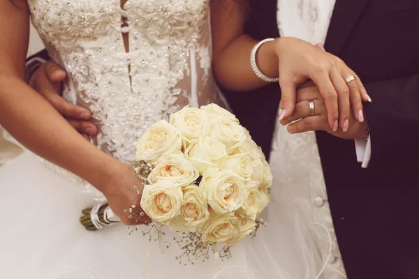 Beautiful bride and groom with bouquet on wedding day holding hands — Stock Photo, Image