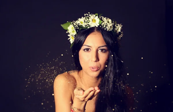 Gorgeous young women with beautiful chaplet flowers blowing glitter on isolated background — Stock Photo, Image