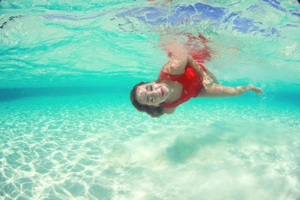 Hermosas mujeres jóvenes en vestido rojo buceando en el océano cerca de las islas Maldivas — Foto de Stock