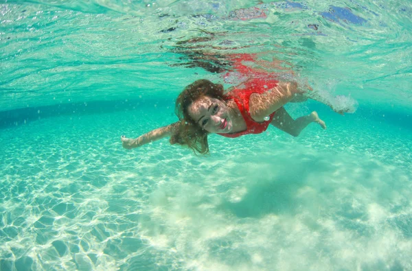 Beautiful young women in red dress diving in the ocean near Maldives islands — Stock Photo, Image