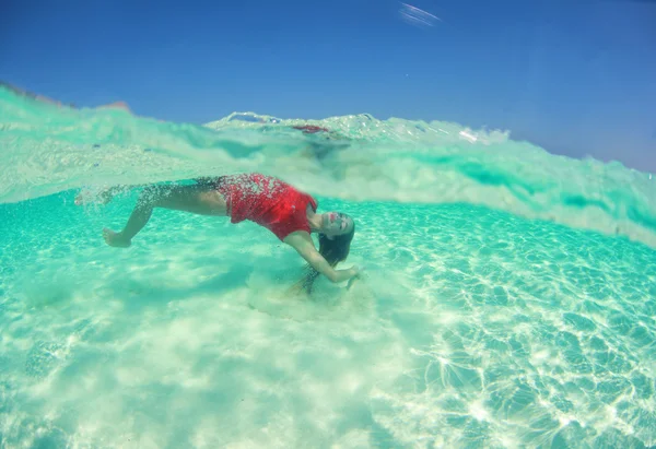 Beautiful young women in red dress diving in the ocean near Maldives islands — Stock Photo, Image