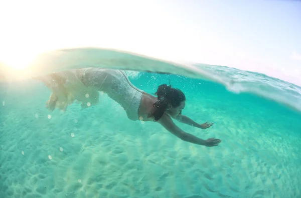 Beautiful young women in dress diving in ocean near Maldives islands — Stock Photo, Image