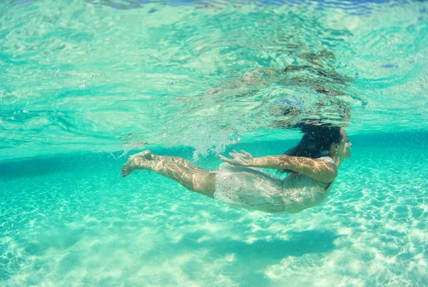 Beautiful young women in dress diving in ocean near Maldives islands — Stock Photo, Image