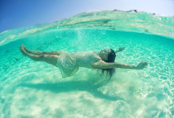 Vackra unga kvinnor i klänning dykning i havet nära Maldiverna öarna — Stockfoto