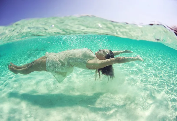 Beautiful young women in dress diving in ocean near Maldives islands — Stock Photo, Image