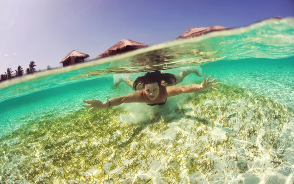 Beautiful young women in dress diving in ocean near Maldives islands — Stock Photo, Image