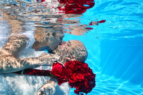 Hermosa novia y novio besándose y abrazándose bajo el agua en la piscina — Foto de Stock