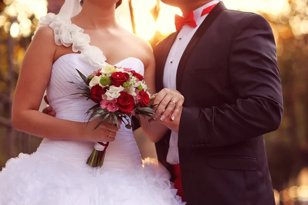 Vackra bruden och brudgummen embracing och hålla blombukett — Stockfoto