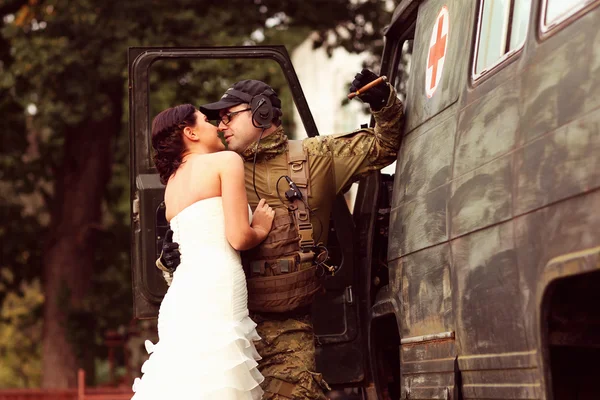 Noiva abraçando com noivo em terno do exército — Fotografia de Stock