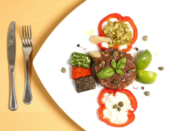 Смачна гастрономічна їжа в ресторані на тарілці з виделкою та ножем — стокове фото