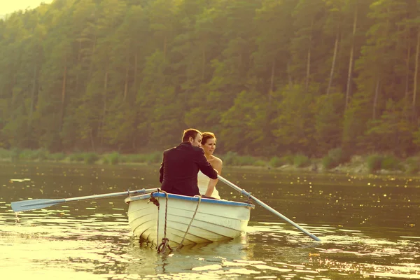 Belle mariée et marié dans un bateau sur le lac — Photo