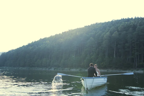 Bela noiva e noivo em um barco no lago — Fotografia de Stock