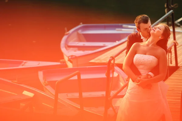 Красивая невеста и жених обнимаются у озера — стоковое фото