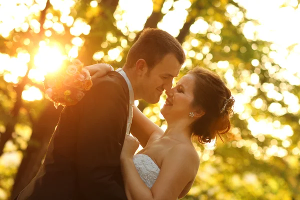 Vackra bruden och brudgummen embracing i skogen — Stockfoto