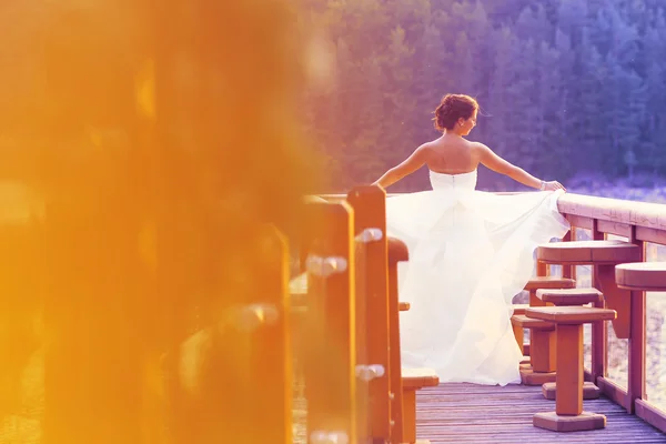 Belle mariée s'amuser près d'un lac — Photo