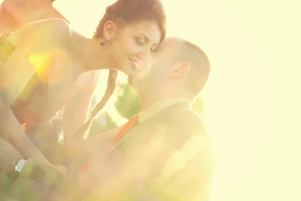 Bela noiva e noivo abraçando e beijando no dia do casamento em bela luz solar — Fotografia de Stock