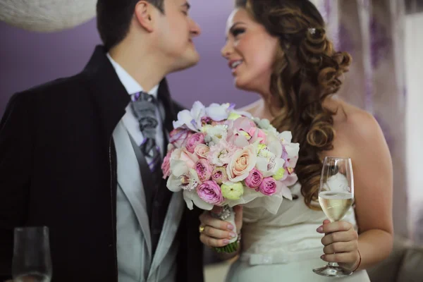 Bella coppia di sposi con bouquet di fiori e champagne — Foto Stock