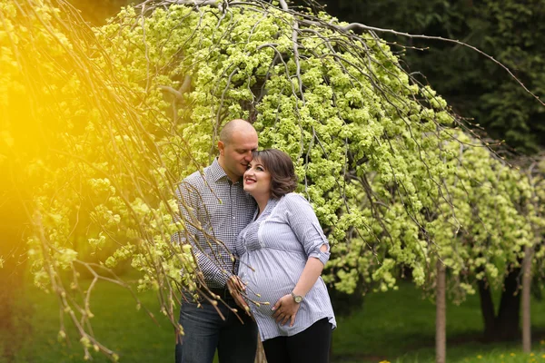Szczęśliwy i młodych ciąży para obejmując w przyrodzie — Zdjęcie stockowe