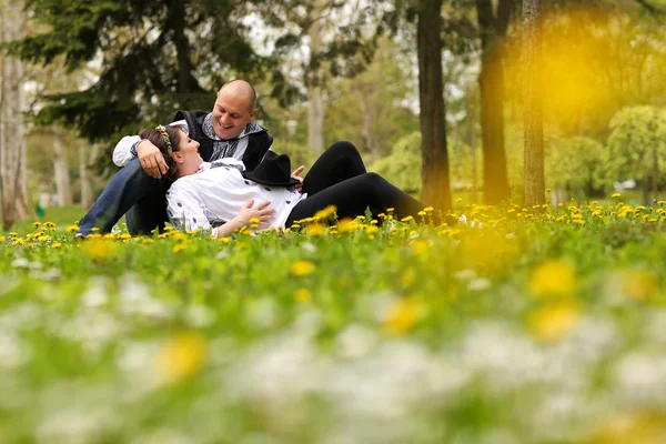 Feliz e jovem casal grávida abraçando na natureza — Fotografia de Stock