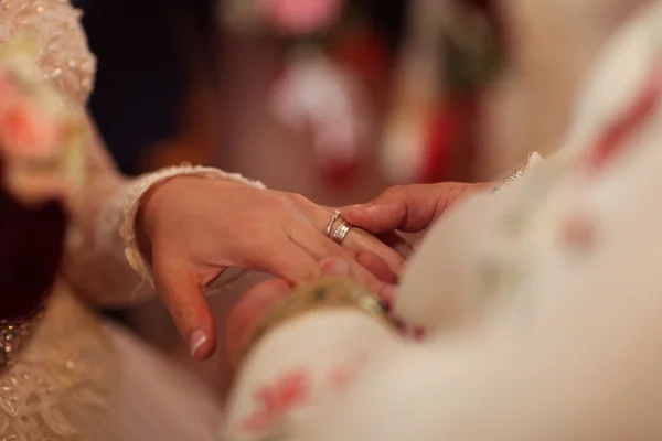 Groom putting wedding ring on bride's thumb — Stock Photo, Image
