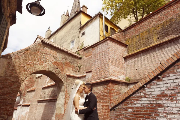 Beautiful bridal couple embracing in old city — Stock Photo, Image