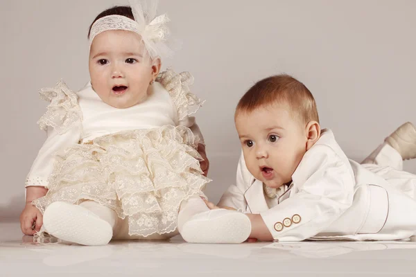 Kis baby boy Szmoking és baba lány mosolyogva elszigetelt háttér — Stock Fotó