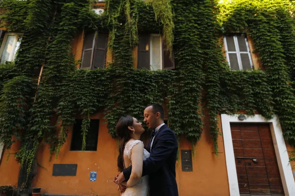 Beautiful bridal couple embracing in old city — Stock Photo, Image