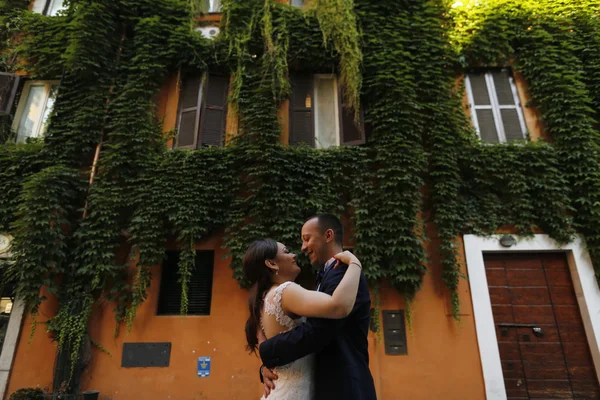 Beautiful bridal couple embracing in old city — Stock Photo, Image