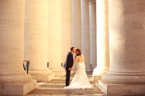 Hermosa pareja nupcial abrazando cerca de columnas —  Fotos de Stock