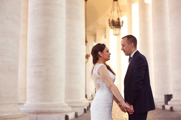 Hermosa pareja nupcial abrazando cerca de columnas —  Fotos de Stock