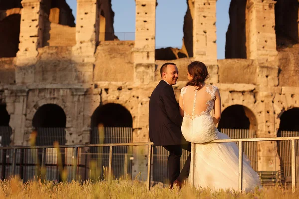 Hermosa pareja de novias relajándose cerca del Coliseo en Roma —  Fotos de Stock