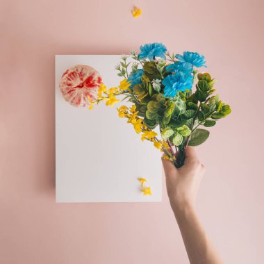 Elinde bir buket bahar çiçeği var. Yumuşak pastel renkler, bahar atmosferi, meyve ve kağıt bileşimi.