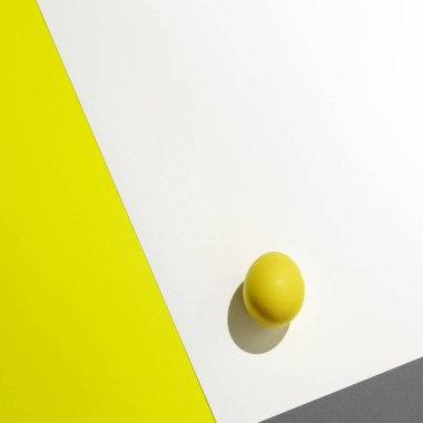 Beyaz arka planda keskin gölgesi olan bir sarı yumurta..