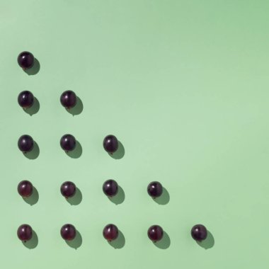 Üçgen şeklinde dizilmiş üzümler. Minimalist sonbahar kompozisyonları.